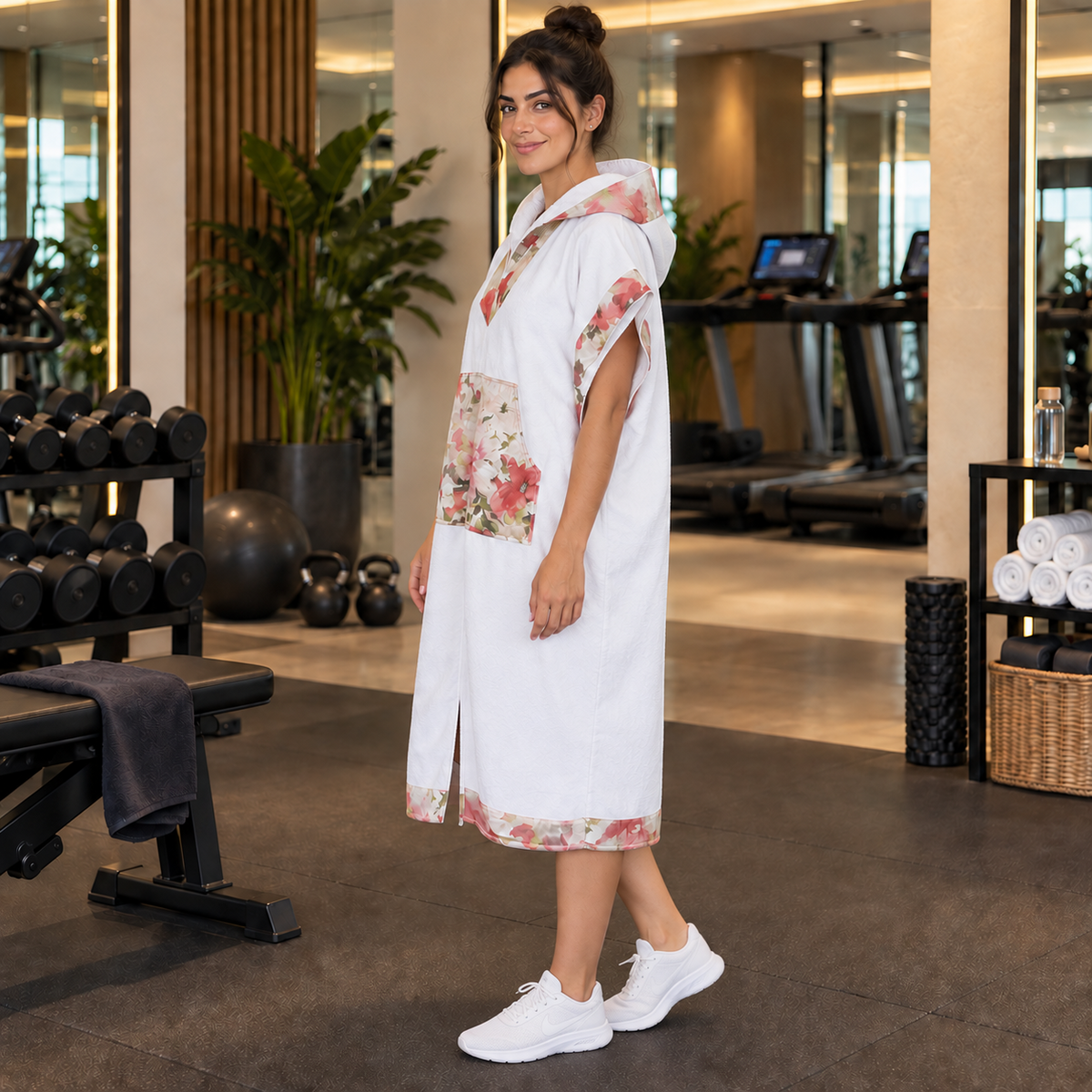 Floréa — poncho femme blanc à finitions florales multicolores, vue de profil en salle de sport