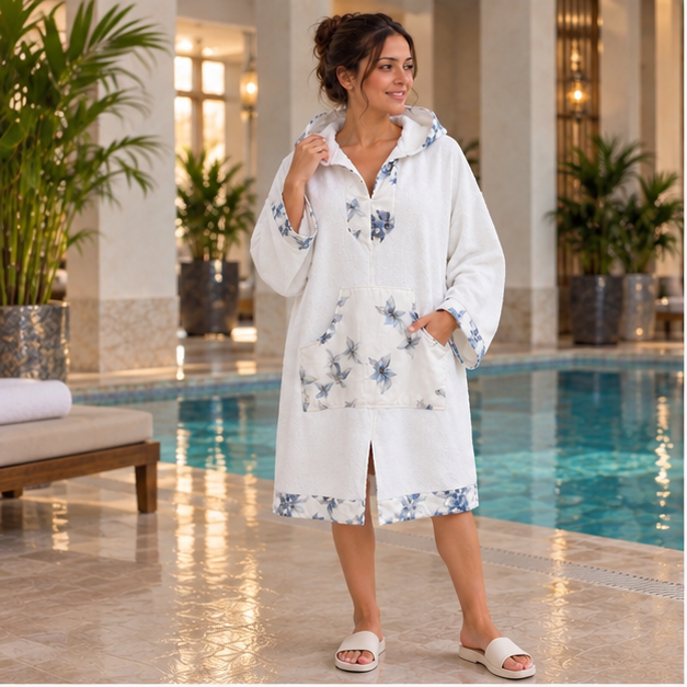 Nacre Bleue — poncho femme blanc à manches longues et finitions florales bleues, vue principale près de la piscine