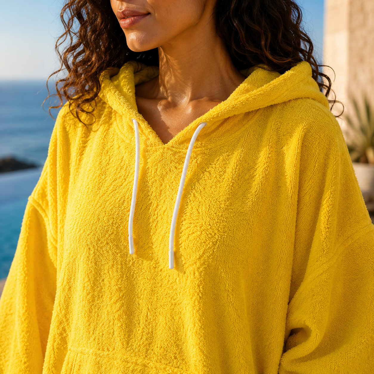 Soléa — détail capuche, cordons et texture du poncho femme jaune